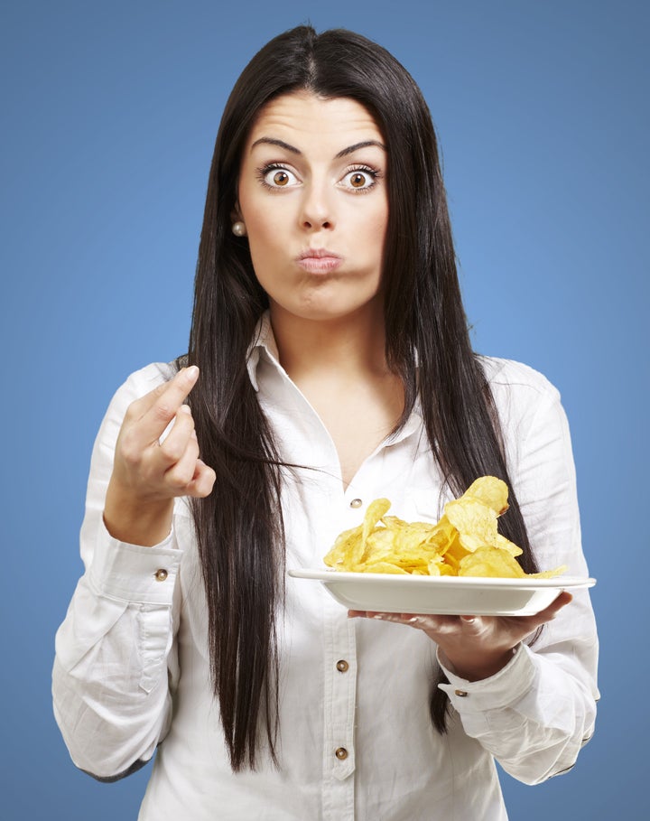 young woman eating potato chips ...