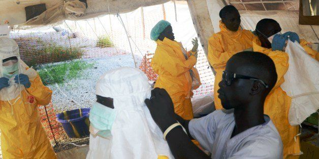 A picture taken on June 28, 2014 shows members of Doctors Without Borders (MSF) putting on protective gear at the isolation ward of the Donka Hospital in Conakry, where people infected with the Ebola virus are being treated. The World Health Organization has warned that Ebola could spread beyond hard-hit Guinea, Liberia and Sierra Leone to neighbouring nations, but insisted that travel bans were not the answer. To date, there have been 635 cases of haemorrhagic fever in Guinea, Liberia and Sierra Leone, most confirmed as Ebola. A total of 399 people have died, 280 of them in Guinea. AFP PHOTO / CELLOU BINANI (Photo credit should read CELLOU BINANI/AFP/Getty Images)
