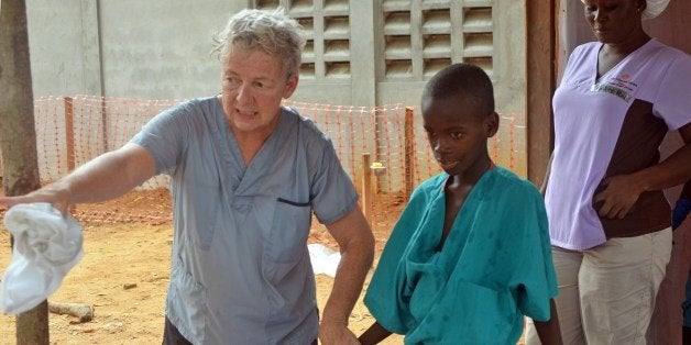 A 10-year-old boy walks with a doctor from Christian charity Samaritan's Purse, after being taken out of quarantine and receiving treatment following his mother's death caused by the ebola virus, in the group's Ebola treatment center, at the ELWA hospital in the Liberian capital Monrovia, on July 24, 2014. A US doctor battling West Africa's Ebola epidemic has himself fallen sick with the disease in Liberia, Samaritan's Purse said on July 27. AFP PHOTO / ZOOM DOSSO (Photo credit should read ZOOM DOSSO/AFP/Getty Images)