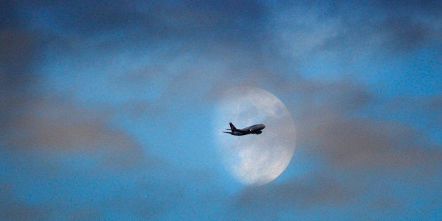 A Lufthansa passenger jet passes the moon on approach to landing at Heathrow Airport. PRESS ASSOCIATION Photo. Issue date: Sa