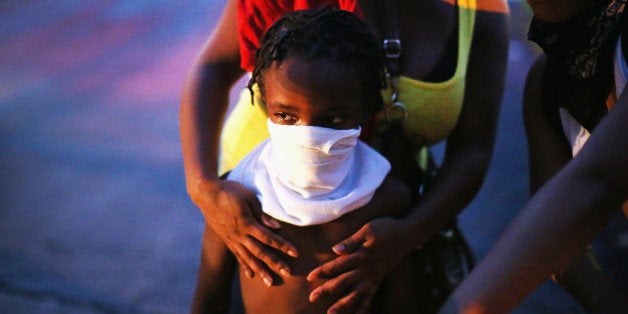 FERGUSON, MO - AUGUST 11: A child uses a rag to shield his face from tear gas being fired by police who used it to force protestors from the business district into nearby neighborhoods on August 11, 2014 in Ferguson, Missouri. Police responded with tear gas and rubber bullets as residents and their supporters protested the shooting by police of an unarmed black teenager named Michael Brown who was killed Saturday in this suburban St. Louis community. Yesterday 32 arrests were made after protests turned into rioting and looting in Ferguson. (Photo by Scott Olson/Getty Images)