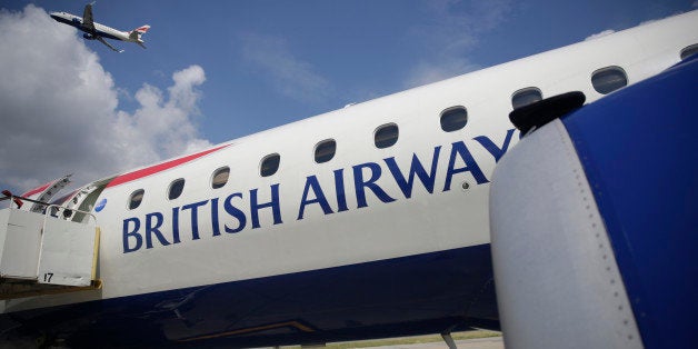 A British Airways jet, operated by IAG SA, climbs after take-off beyond a parked airliner at London City Airport Ltd. in London, U.K., on Wednesday, Aug. 6, 2014. London City Airport, where a short runway has prevented operations with long-haul planes, said it's in talks about flights to the Middle East, Turkey and Russia as new jets bring more distant destinations within reach. Photographer: Matthew Lloyd/Bloomberg via Getty Images