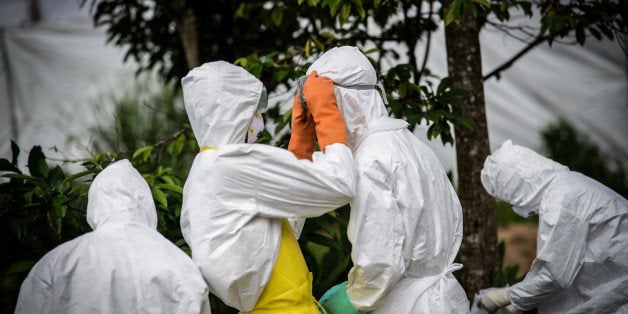 KENEMA, SIERRA LEONE - AUGUST 24: A group of young volunteers wear special uniforms for the burials and sterilizing the area in Kptema graveyard under the threat of Ebola virus in Kenema, Sierra Leone on August 24, 2014. People work for 6 dollars per a day in burial and sterilizing works in Kenema where the infection of the virus is mostly seen. (Photo by Mohammed Elshamy/Anadolu Agency/Getty Images)