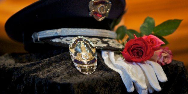 The 49th Los Angeles Chief of Police Daryl Gates' hat, badge and white gloves, are displayed atop a white columned pedestal nearby closed casket on display at the LAPD Administration Building Civic Auditorium on Monday, April 26, 2010, in Los Angeles. Los Angeles Police Chief Gates, who resigned in the wake of 1992 rioting that followed the Rodney King beating trial, died Friday, April 16, 2010 at his Newport Beach home. He was 83. (AP Photo/Damian Dovarganes)