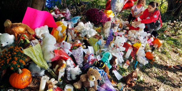 Jessica Bridges and her three-year-old daughter Madison Bridges place flowers at a growing shrine for Autumn Pasquale Wednesday, Oct. 24, 2012, in Clayton, N.J., near where the missing 12-year-old girl's body was found in a home's recycling bin. The body of Autumn Pasquale was found around 10 p.m. Monday, just blocks away from her house. Two teenage brothers were charged Tuesday with murdering Pasquale who had been missing since the weekend, prompting a frantic search by her small hometown until her body was found stuffed into a home recycling bin. (AP Photo/Mel Evans)