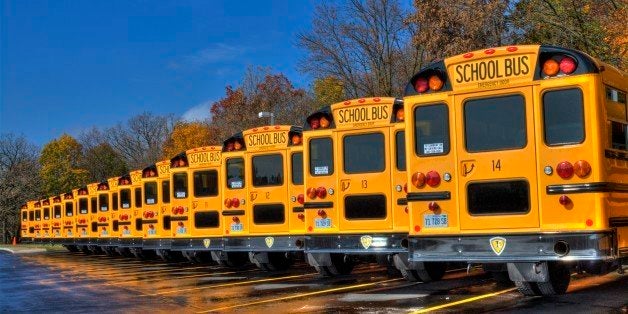 This is an HDR photo of a line of parked school buses at Millburn school in Millburn Illinois