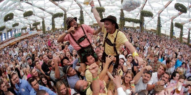 In this photo taken with a fisheye lens, people celebrate the opening of the 181th Oktoberfest beer festival in Munich, southern Germany, Saturday, Sept. 20, 2014. The world's largest beer festival will be held from Sept. 20 to Oct. 5, 2014. (AP Photo/Matthias Schrader)