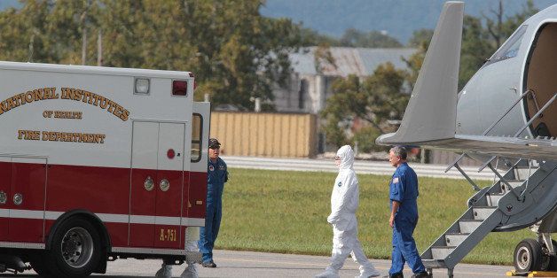 An American doctor who was exposed to Ebola virus while volunteering in Sierra Leone walks across the tarmac after disembarks from a Gulfstream jet Sunday, Sept. 28, 2014, at the Frederick (Md) Municipal Airport. The doctor, who is not showing signs of being infected, will be transported to the National Institutes of Health facility in Bethesda, Md.(AP Photo/Timothy Jacobsen)