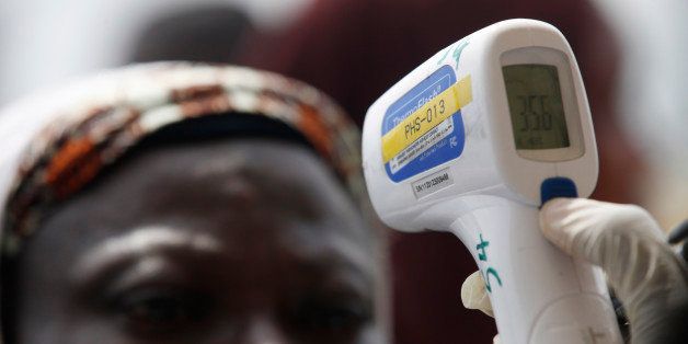A Nigerian port official uses a thermometer to screen Muslim pilgrims for Ebola at the Hajj camp before boarding a plane for Saudi Arabia at the Murtala Muhammed International Airport in Lagos, Nigeria Thursday, Sept, 18. 2014. ( AP Photo/Sunday Alamba)