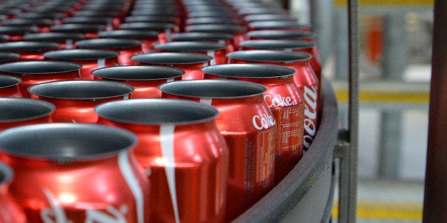 Empty Coca-Cola Classic cans move along a conveyor to be filled and sealed at a Coca-Cola Amatil Ltd. production facility in Melbourne, Australia, on Tuesday, Aug. 19, 2014. Coca-Cola Amatil flagged a second consecutive drop in full-year earnings amid weak consumer confidence and rising costs in Indonesia. Photographer: Carla Gottgens/Bloomberg via Getty Images