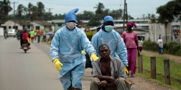 Residents of the St. Paul Bridge neighborhood wearing personal protective equipment take a man suspected of carrying the Ebola virus to the Island Clinic in Monrovia, Liberia, Sunday Sept. 28, 2014. Six months into the worldᅢ까タᅡルs worst-ever Ebola outbreak, and the first to happen in an unprepared West Africa, the gap between what has been sent by other countries and private groups and what is desperately needed is huge. Even as countries try to marshal more resources to close the gap, those needs threaten to become much greater, and possibly even insurmountable. (AP Photo/Jerome Delay)
