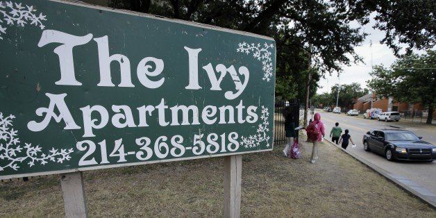 Children walk past a sign by The Ivy Apartments, Thursday, Oct. 2, 2014, in Dallas. A family who resides at the complex had contact with a man diagnosed with the Ebola virus. Dallas officials have asked the family to remain in their home. (AP Photo/Tony Gutierrez)