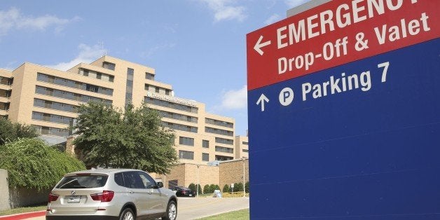 A vehicle drives up the driveway to the Texas Health Presbyterian Hospital in Dallas, Tuesday, Sept. 30, 2014. A patient in the hospital is being teated for Ebola. (AP Photo/LM Otero)