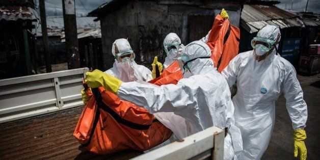 MONROVIA, LIBERIA - OCTOBER 15: Red Cross members carry dead body of Mambodou Aliyu (35) died due to the Ebola virus,, in Monrovia, Liberia on 15 October, 2014. (Photo by Mohammed Elshamy/Anadolu Agency/Getty Images)