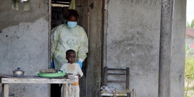 A member of the NGO U Fondation leaves a house after visiting quarantined family members suffering from the Ebola virus, on October 16, 2014 in Monrovia. Liberian doctors and nurses at the frontline of the Ebola epidemic returned to work on October 15, 2014 after a two-day strike demanding hazard pay in the country hardest hit by the crisis. Liberia has been the hardest hit by the epidemic, with 2,458 deaths out of 4,249 cases, about half the global total, according to World Health Organization figures. AFP PHOTO / ZOOM DOSSO (Photo credit should read ZOOM DOSSO/AFP/Getty Images)