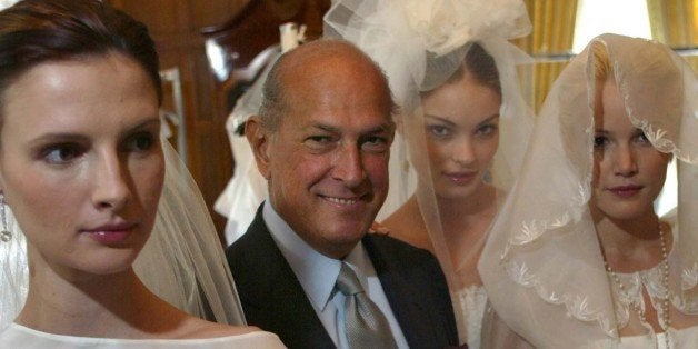 Designer Oscar de la Renta is flanked by models wearing wedding dresses from his first bridal collection in New York, Monday Oct. 7, 2002. From left are Elodie, de la Renta, Valentina, and Brooke. (AP Photo/Stuart Ramson)