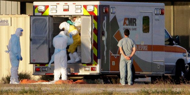 Medical staff in protective gear escort Nina Pham, exiting the ambulance, to a nearby aircraft at Love Field, Thursday, Oct. 16, 2014, in Dallas. Pham, a nurse at Texas Health Presbyterian Hospital Dallas, was diagnosed with the Ebola virus after caring for Thomas Eric Duncan who died of the same virus. (AP Photo/Tony Gutierrez)