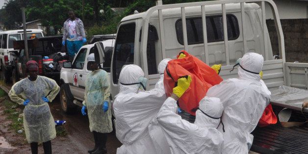 Health workers load a body of a man at a back of a truck suspected to have died of Ebola virus in Paynesville Community situated on the outskirts of Monrovia, Liberia, Tuesday, Oct. 21, 2014. Liberian President Ellen Johnson Sirleaf said Ebola has killed more than 2,000 people in her country and has brought it to "a standstill," noting that Liberia and two other badly hit countries were already weakened by years of war. (AP Photo/Abbas Dulleh)