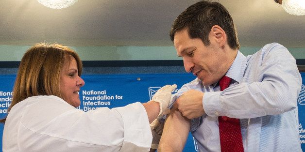 Dr. Thomas Frieden, director of the Centers for Disease Control and Prevention, receives a flu shot from Sharon Bonadies at the conclusion of a news conference at the National Press Club in Washington, Thursday, Sept. 18, 2014. "Vaccination is the single most important step everyone 6 months of age and older can take to protect themselves and their families against influenza," said Frieden. Influenza hospitalized a surprisingly high number of young and middle-aged adults last winter, and this time around the government wants more of them vaccinated. (AP Photo/J. David Ake)