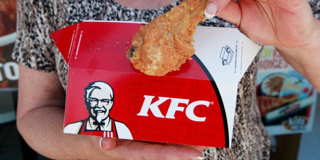 A customer hold a piece of Kentucky Fried Chicken outside a KFC restaurant, Tuesday, July 13, 2010, in Mountain View, Calif. Yum Brands Inc., which owns Taco Bell, Pizza Hut and KFC, reports second-quarter results after the close of regular trading. (AP Photo/Paul Sakuma)