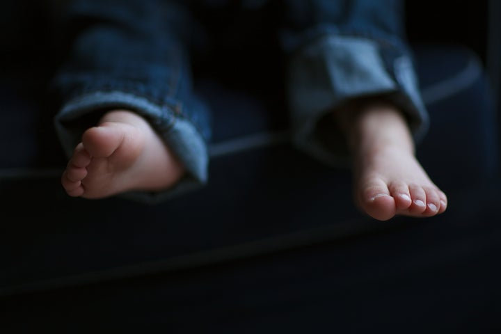 Toddler boy toes with jeans.