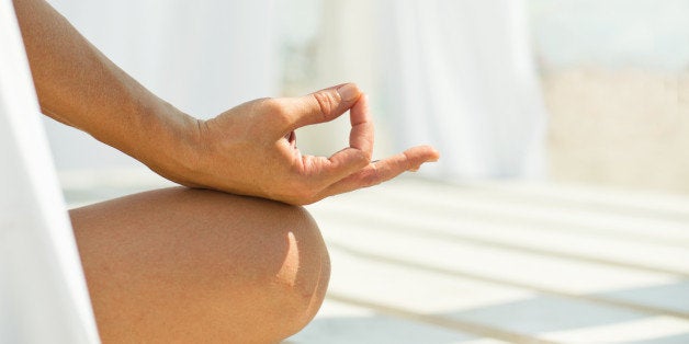 woman meditating on beach in...