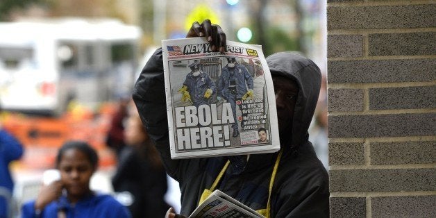 A newspaper vendor holds up a copy of the NY Post in front of the entrance to Bellevue Hospital October 24, 2014 in New York, the morning after it was confirmed that Craig Spencer, a member of Doctors Without Borders, who recently returned to New York from West Africa tested positive for Ebola. New York confirmed the first case of Ebola in the largest city in the United States as the EU dramatically ramped up aid Friday to contain the killer epidemic ravaging west Africa.The EU announcement of one billion euros ($1.3 billion) for the worst-hit countries comes as fears of a spread of the virus grew, with the first confirmed case in Mali, where a two-year-old girl has tested positive. Craig Spencer was placed in isolation at Manhattan's Bellevue Hospital Center, officials said. AFP PHOTO / Timothy A. Clary (Photo credit should read TIMOTHY A. CLARY/AFP/Getty Images)