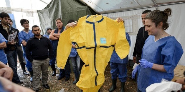 Health workers of the International Federation of Red Cross (IFRC) and Medical charity Medecins Sans Frontieres (MSF) take part in a pre-deployment training for staff heading to the Ebola area on October 29, 2014 at the IFRC headquarters in Geneva. West Africa is the epicentre of the Ebola outbreak which has claimed the lives of nearly 5,000 people. The often deadly virus is spread only through direct contact with the bodily fluids of an infected person showing symptoms such as fever or vomiting. AFP PHOTO / FABRICE COFFRINI (Photo credit should read FABRICE COFFRINI/AFP/Getty Images)