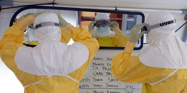 Workers wearing a Personal Protective Equipment (PPE) prepare before leaving for a high-risk area of the Elwa hospital runned by Medecins Sans Frontieres (Doctors without Borders), on September 7, 2014 in Monrovia. President Barack Obama said in an interview aired Sunday the US military would help in the fight against fast-spreading Ebola in Africa, but said it would be months before the epidemic slows. Obama said that, in its current form, he did not believe Ebola would reach the United States, but warned the virus could mutate and become a much greater threat to those outside Africa. AFP PHOTO / DOMINIQUE FAGET (Photo credit should read DOMINIQUE FAGET/AFP/Getty Images)