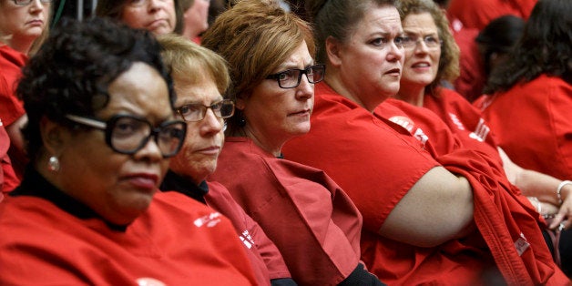 Members of National Nurses United, the largest union and professional association of registered nurses in the U.S., listen from the audience on Capitol Hill in Washington, Friday, Oct. 24, 2014, as the House Oversight Committee examines the government's response to the Ebola outbreak. On Thursday, a fourth Ebola case was diagnosed in the U.S. ￃﾢￂﾀￂﾔ a doctor in New York City who had treated patients in Guinea. (AP Photo/J. Scott Applewhite)