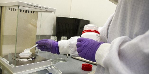 An employee measures a powder on electronic scales in the Gentechnological laboratory at the Bavarian Nordic A/S biotechnology company, where the research into infectious diseases, including the ebola vaccine, takes place in Kvistgaard, Denmark, on Friday, Oct. 31, 2014. The ebola vaccine combines a shot from Johnson & Johnson's Janssen unit in the Netherlands with one developed by Bavarian Nordic, the U.S.-based company said. Photographer: Freya Ingrid Morales/Bloomberg via Getty Images
