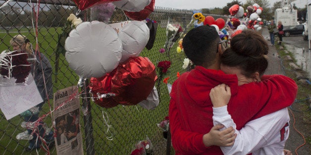 MARYSVILLE, WA - OCTOBER 26: Members of the community and students grieve beside a makeshift memorial at Marysville-Pilchuck High School on October 26, 2014 in Marysville, Washington. High school freshman Jaylen Fryberg shot five students at the high school's cafeteria, injuring four, killing one and then killing himself on October 24th. (Photo by David Ryder/Getty Images)