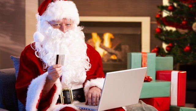 Santa Claus using computer purchasing Christmas presents on internet paying with credit card.?