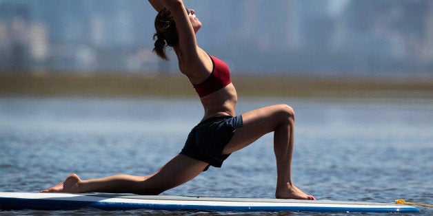 MIAMI, FL - JULY 10: Yoga instructor Sarah Henry leads a class during a paddleboard yoga session at Adventure Sports Miami on July 10, 2011 in Miami, Florida. The paddle board is said to give the bodyᅢ까タᅡルs core more of a workout then in a gym since the platform is unstable and one must use the muscles to remain balanced on the board. (Photo by Joe Raedle/Getty Images)
