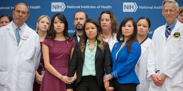 Patient Nina Pham, center, with her mother Diana Berry, right, and sister Cathy Pham, left, and members of the NIH staff outside during a news conference at NIH in Bethesda, Md., Friday, Oct. 24, 2014. Pham, the first nurse diagnosed with Ebola after treating an infected man at a Dallas hospital is free of the virus. The 26-year-old Pham arrived last week at the NIH Clinical Center. She had been flown there from Texas Health Presbyterian Hospital Dallas. (AP Photo/Pablo Martinez Monsivais)