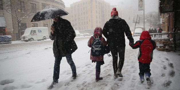 NEW YORK, NY - FEBRUARY 13: A person walks two kids to school during a snowstorm on February 13, 2014 in New York City. Heavy snow and high winds made for a hard morning commute in the city. (Photo by John Moore/Getty Images)