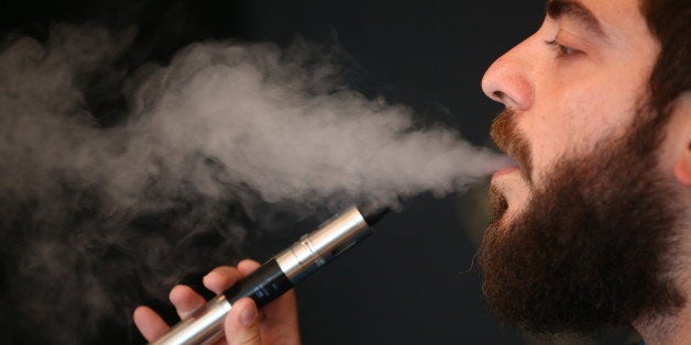 LONDON, ENGLAND - AUGUST 27: Vape Lab employee Leonardo Verzaro uses an E-Cigarette while working on August 27, 2014 in London, England. The Department of Health have ruled out the outlawing of 'e-cigs' in enclosed spaces in England, despite calls by WHO, The World Health Organisation to do so. WHO have recommended a ban on indoor smoking of e-cigs as part of tougher regulation of products dangerous to children. (Photo by Dan Kitwood/Getty Images)