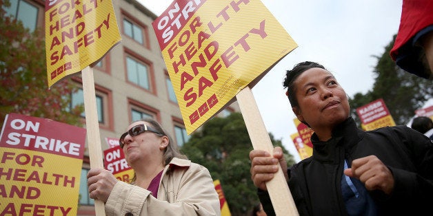SAN FRANCISCO, CA - NOVEMBER 11: Nurses carry signs as they strike outside of Kaiser Permanente hospital on November 11, 2014 in San Francisco, California. Nearly 18,000 Kaiser Permanente nurses in Northern California are staging a two-day strike amidst contract negotiations and to demand better working conditions, training and optimal safeguards for treating ebola. (Photo by Justin Sullivan/Getty Images)