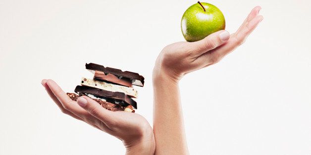 Woman cupping green apple above chocolate bars