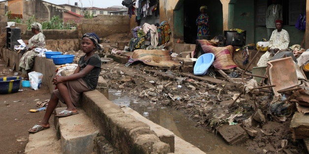 Residents sit outside their flooded home in Ibadan, Nigeria , Friday, Sept 2, 2011. Flash flooding across Nigeria's southwest killed at least 102 people in the last week, the country's Red Cross said .Some 1,500 people remain displaced by the torrential downpours, officials said.The major flood hit hardest in Oyo state's capital of Ibadan. Heavy rains there on Friday made a local dam overflow, sending water crashing through the informal settlements surrounding the city. The water also damaged three bridges in the area, trapping people in their neighborhoods. (AP Photo/Sunday Alamba)