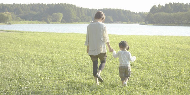 Rear view of mother and daughters taking a walk in a park