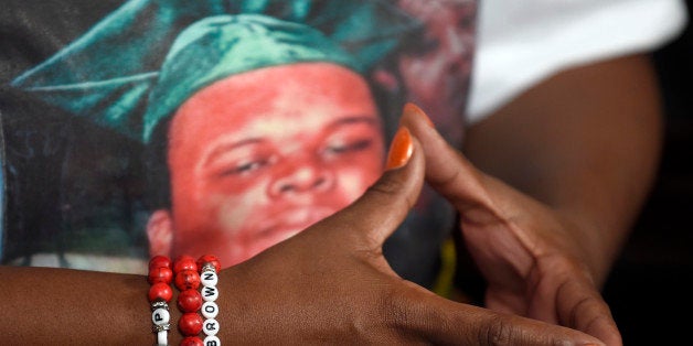 The mother of Michael Brown, Lesley McSpadden, wears a bracelet bearing her son's name and a shirt with his photograph on it as she talks to The Associated Press during an interview in Washington, Saturday, Sept. 27, 2014. Michael Brown's parents expressed anger at Ferguson police who wore bracelets expressing support for Darren Wilson, the police officer who shot their unarmed 18-year-old son last month. McSpadden says that lets her know "how they feel." (AP Photo/Susan Walsh)