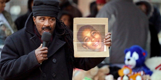 Activist Art McCoy holds a photo of Tamir Rice before a protest march at Cudell Park in Cleveland, Monday, Nov. 24, 2014. The 12-year-old was fatally shot by a Cleveland police officer Saturday after he reportedly pulled a replica gun at the city park. (AP Photo/Mark Duncan)