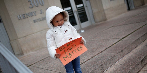 WASHINGTON, DC - NOVEMBER 25: 4 year old Marley Hendrix Totten joins a group of protesters as they gather outside the headquarters of the Washington DC Metropolitan Police Department as part of a planned '28 Hours for Mike Brown' protest November 25, 2014 in Washington, DC. Protests have taken place across the United States in the wake of a Ferguson, Missouri grand jury's decision not to indict police officer Darren Wilson in the fatal shooting of 18 year old Michael Brown. (Photo by Win McNamee/Getty Images)