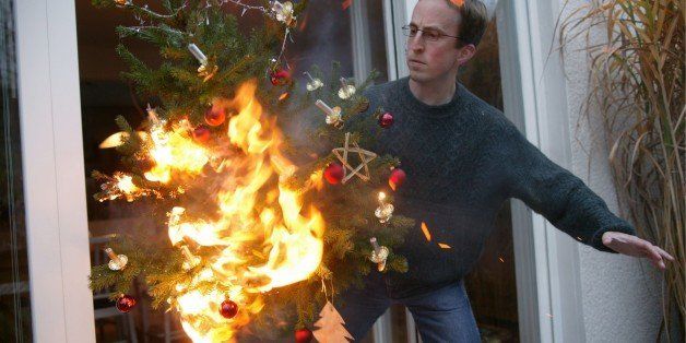 GERMANY - NOVEMBER 14: Man is running with a burning christmas tree out of the house. (Photo by Ulrich Baumgarten via Getty Images)