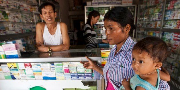 This Aug. 26, 2009 photo shows a merchant in Pailin, Cambodia speaking with a woman as she holds her sick child. Malaria parasites in the Thai-Cambodia area of Pailin, Cambodia have become resistant to artemisinin-based therapies according to Non Governmental Agencies working in the region. If this drug stops working, there's no good replacement to combat a disease that kills 1 million annually. As a result, earlier this year international medical leaders declared resistant malaria here a health emergency. (AP Photo/David Longstreath)