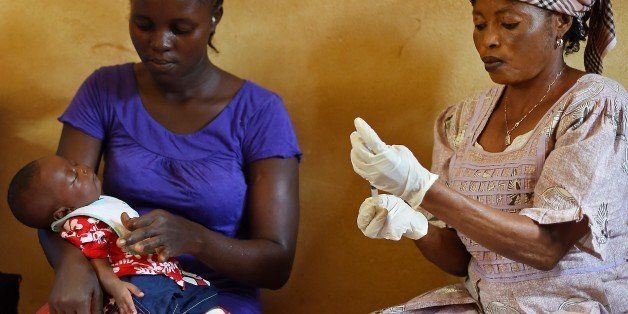 A baby is prepared for a vaccination during a routine doctor's visit at the Kuntorloh Community Health Centre in the outskirts of Freetown on November 14, 2014. Ebola-hit Sierra Leone faces social and economic disaster as gains made since the country's ruinous civil war are wiped out by the epidemic, according to a major study. Damage to most sectors of the economy will see growth shrink from 20.1 percent last year to just five percent in 2014, the finance ministry and the United Nations Development Programme (UNDP) found. AFP PHOTO/ FRANCISCO LEONG (Photo credit should read FRANCISCO LEONG/AFP/Getty Images)