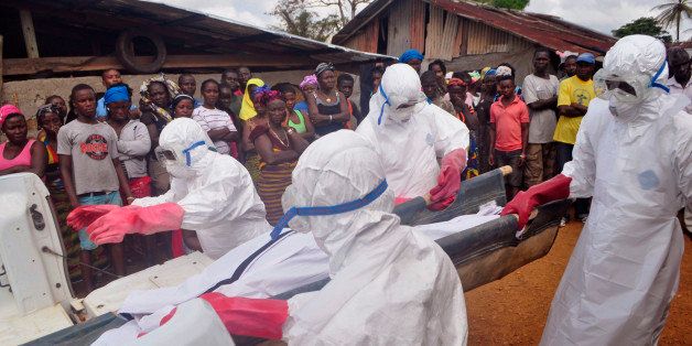 Ebola health care workers carry the body of a man suspected of dying from the Ebola virus in a small village Gbah on the outskirts of Monrovia, Liberia, Friday, Dec. 5, 2014. A U.N. peacekeeper who contracted Ebola in Liberia will be flown to the Netherlands for treatment, a Dutch Health Ministry spokeswoman said Friday. (AP Photo/ Abbas Dulleh)