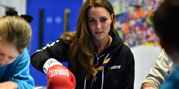 Britain's Kate, Duchess of Cambridge learns about disability by wearing a boxing glove to undertake simple tasks as she meets with children at the newly established 23rd Poplar Beaver Scout Colony in east London, Tuesday Dec. 16, 2014, in support of The Scout Association's "Better Prepared" campaign. (AP Photo/Ben Stansall, Pool)