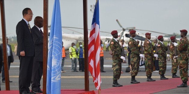 UN chief Ban Ki-moon (L) reviews the troops with Liberian Vice President Joseph Boakai after arriving at the Monrovia airport, on December 19, 2014, on the first stop of a visit to Ebola-ravaged west African countries for a first-hand assessment of global efforts to fight the epidemic. AFP PHOTO ZOOM DOSSO (Photo credit should read ZOOM DOSSO/AFP/Getty Images)